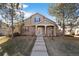 Charming two-story home with a landscaped yard, pillars supporting an entry roof and a well maintained lawn at 7944 E Lowry Blvd, Denver, CO 80230