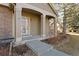 Inviting front porch with stone accents, a decorative storm door, and sturdy pillars that support the porch overhang at 7944 E Lowry Blvd, Denver, CO 80230