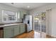 Bright kitchen with stainless steel refrigerator, wood floors, and sliding door to the outdoor area at 7944 E Lowry Blvd, Denver, CO 80230