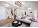 Spacious open-concept living room featuring a modern sofa, fireplace, and wooden staircase leading to the upper level at 7944 E Lowry Blvd, Denver, CO 80230