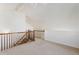 Upstairs loft with carpet flooring, wood railings, and natural light at 7944 E Lowry Blvd, Denver, CO 80230