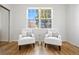 Bright sitting area with large window, hardwood floors, and two stylish chairs at 7944 E Lowry Blvd, Denver, CO 80230