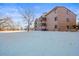 Rear view of condo building showcasing snow-covered grounds at 6505 Kalua Rd # 204B, Boulder, CO 80301