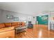 Living room with hardwood floors, orange couch, and a world map accent wall at 6505 Kalua Rd # 204B, Boulder, CO 80301