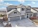 Beautiful two-story home with grey siding, stone accents, and a three-car garage at 20223 Terrace View Dr, Parker, CO 80134