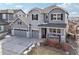 Charming gray two-story home with stone accents, a covered porch, and a well-maintained yard at 20223 Terrace View Dr, Parker, CO 80134