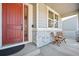 Inviting front porch with a red door, decorative glass, and seating area at 20223 Terrace View Dr, Parker, CO 80134