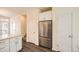 Bright kitchen with white cabinets, stainless steel refrigerator, and wood floors at 12898 King St, Broomfield, CO 80020