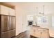 Kitchen area with stainless steel refrigerator, granite countertop and view of a fireplace in living room at 12898 King St, Broomfield, CO 80020