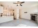 Spacious living room with a fireplace, ceiling fan, and view of open kitchen at 12898 King St, Broomfield, CO 80020