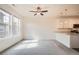 Bright living room featuring two windows and an open floor plan leading into the kitchen at 12898 King St, Broomfield, CO 80020