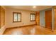 Sunlit bedroom features hardwood floors, neutral walls, and classic trim around the windows at 4850 Forest Hill Rd, Evergreen, CO 80439