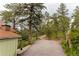 Asphalt driveway leading through mature trees to the property at 4850 Forest Hill Rd, Evergreen, CO 80439