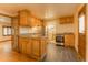A functional kitchen with stainless appliances, wood cabinets, and an adjoining laundry area at 4850 Forest Hill Rd, Evergreen, CO 80439