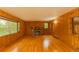 Cozy living room with wood paneled walls, hardwood floors, and a rustic stone fireplace at 4850 Forest Hill Rd, Evergreen, CO 80439