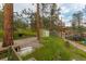 Home's yard with a storage shed, lush green grass and mature trees at 4850 Forest Hill Rd, Evergreen, CO 80439