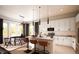 Modern kitchen with white cabinets, quartz countertops, stainless steel appliances, and stylish pendant lighting at 1950 Grayside Cir, Castle Rock, CO 80109