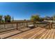 A spacious wooden deck with a view of a lush field under a clear blue sky at 18128 Sage Brush Way, Brighton, CO 80603