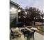 Backyard area with chairs, table, BBQ pit, and access to a raised wood deck with stairs at 18128 Sage Brush Way, Brighton, CO 80603