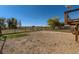 Large fenced backyard area featuring dirt landscaping, greenery and partial view of the house at 18128 Sage Brush Way, Brighton, CO 80603