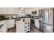 Modern kitchen with white cabinets, kitchen island, and stainless steel appliances at 18128 Sage Brush Way, Brighton, CO 80603