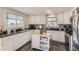 Bright kitchen with white cabinets, dark countertops, and a butcher block island at 18128 Sage Brush Way, Brighton, CO 80603