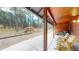 Inviting covered porch featuring natural wood finishes, comfortable seating, and a charming greenhouse nestled in a wooded setting at 12655 Greenland Acres Rd, Larkspur, CO 80118