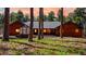 Charming cabin-style home with wood siding, metal roof, and inviting greenery at 12655 Greenland Acres Rd, Larkspur, CO 80118