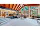 Open-concept living room with vaulted wood ceilings, large windows, and staircase at 12655 Greenland Acres Rd, Larkspur, CO 80118