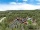 Beautiful aerial view of a luxury home on acreage nestled in the forest with lush landscaping at 44 N Big Meadow Trl, Franktown, CO 80116