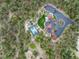 Overhead view of wooded acreage featuring a tennis court and a luxury house with circular driveway at 44 N Big Meadow Trl, Franktown, CO 80116