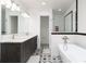 Stylish bathroom featuring a double vanity, decorative tile floor, and a luxurious soaking tub with a glass-enclosed shower at 44 N Big Meadow Trl, Franktown, CO 80116