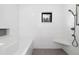 Modern bath features tiled walls, built-in tub, shower bench, and a small window at 44 N Big Meadow Trl, Franktown, CO 80116