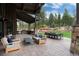 Outdoor covered patio includes a kitchen, outdoor seating, dining area, and lush backyard at 44 N Big Meadow Trl, Franktown, CO 80116