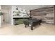 Basement game room featuring a stylish ping pong table, rustic wood wall, sink, and mini-fridge for entertaining guests at 44 N Big Meadow Trl, Franktown, CO 80116