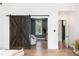 Hallway with wooden sliding barn door leading to a sitting area at 44 N Big Meadow Trl, Franktown, CO 80116