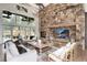 Cozy living room with a stone fireplace, vaulted ceilings, and large windows overlooking the backyard at 44 N Big Meadow Trl, Franktown, CO 80116