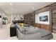 Basement living room with a large gray sectional, rustic wood wall, and entertainment area, perfect for relaxation and media at 44 N Big Meadow Trl, Franktown, CO 80116