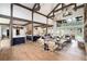 Open-concept living space with exposed beams, hardwood floors, and a seamless flow to the kitchen and dining area at 44 N Big Meadow Trl, Franktown, CO 80116