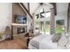 Bright main bedroom featuring fireplace, wood beams, and large windows with backyard views at 44 N Big Meadow Trl, Franktown, CO 80116