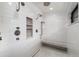 Luxury shower featuring marble tiling, a built-in bench, and multiple shower heads at 44 N Big Meadow Trl, Franktown, CO 80116