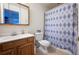 Bathroom with a single sink vanity, toilet, and a shower with a blue patterned curtain at 4927 Tarcoola Ln, Highlands Ranch, CO 80130