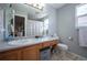 Bright bathroom featuring a single sink vanity, a large mirror, and a shower with a striped curtain at 4927 Tarcoola Ln, Highlands Ranch, CO 80130