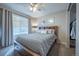 A cozy bedroom featuring a wood-framed bed with storage, a ceiling fan, and window with blinds and curtains at 4927 Tarcoola Ln, Highlands Ranch, CO 80130