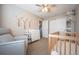 Bedroom with a glider chair, a changing table, macrame wall hangings, and a wooden crib at 4927 Tarcoola Ln, Highlands Ranch, CO 80130