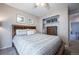 A well-lit bedroom featuring a wood-framed bed with storage, a ceiling fan, and closet with a dresser at 4927 Tarcoola Ln, Highlands Ranch, CO 80130