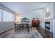 A spacious dining room with dark hardwood floors, a modern table, and a fireplace with an artistic mantle at 4927 Tarcoola Ln, Highlands Ranch, CO 80130