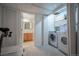 A well-equipped laundry room with washer, dryer, and convenient access to a nearby full-sized bathroom at 4927 Tarcoola Ln, Highlands Ranch, CO 80130