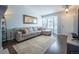 Bright living room with a comfortable gray sofa, hardwood floors, and a large bay window at 4927 Tarcoola Ln, Highlands Ranch, CO 80130