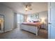 A sunny main bedroom featuring neutral walls, a ceiling fan, an ensuite, and a window with blinds and curtains at 4927 Tarcoola Ln, Highlands Ranch, CO 80130